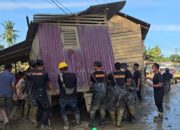 Bahu Membahu, Brimob Pindahkan Rumah Terseret Banjir yang Melintang di Jalan Nasional Tamiang–Langsa